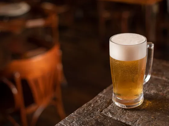 Un boccale di birra chiara su un tavolo di legno